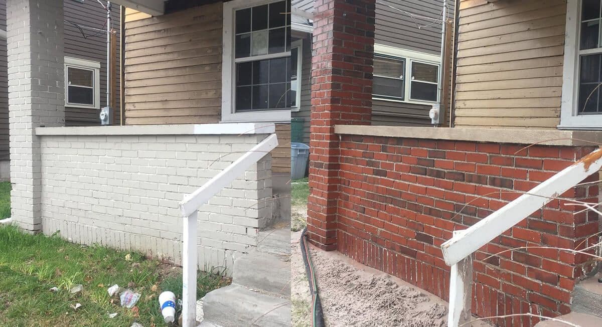 A brick house with stairs leading up to it and a white railing